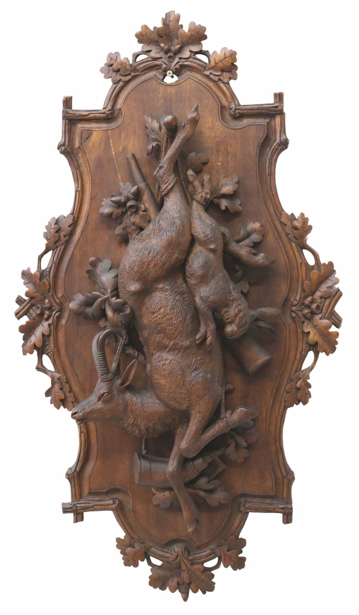 GERMAN BLACK FOREST CARVED GAME TROPHY WALL PLAQUE: Large Black Forest carved game trophy wall plaque, early 20th c., the shaped border in a branch motif crested by leaves and acorns, having relief carved ram, rabbit, rifle, and horn, restoration to ra