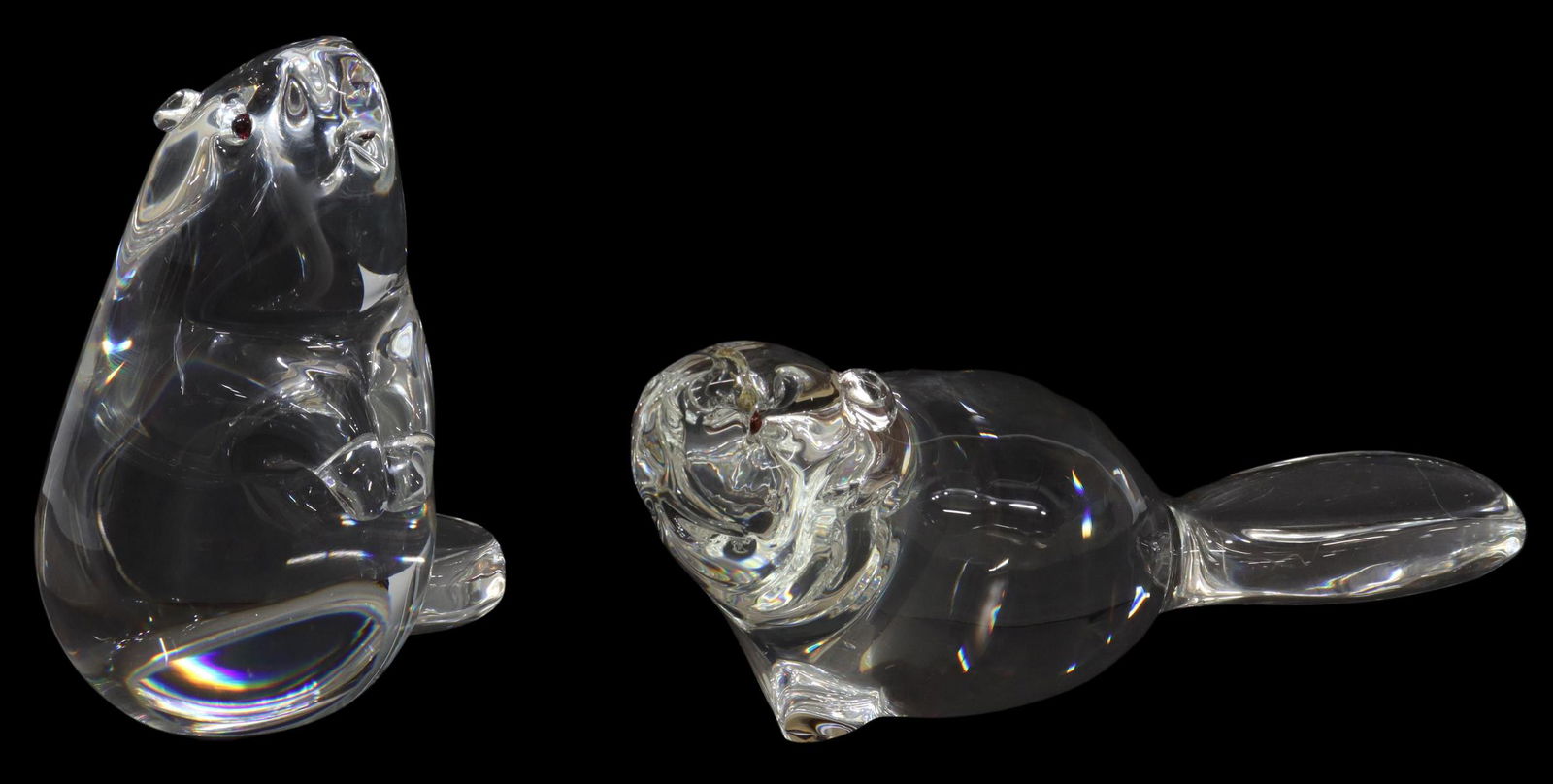 (2) STEUBEN LLOYD ATKINS GLASS BEAVER FIGURES: (lot of 2) Steuben colorless leaded art glass figures, Beavers, designed by Lloyd Atkins (American, b.1922), with inset garnet eyes, engraved signature, surface scratches underfoot, (one) approx 6.25"