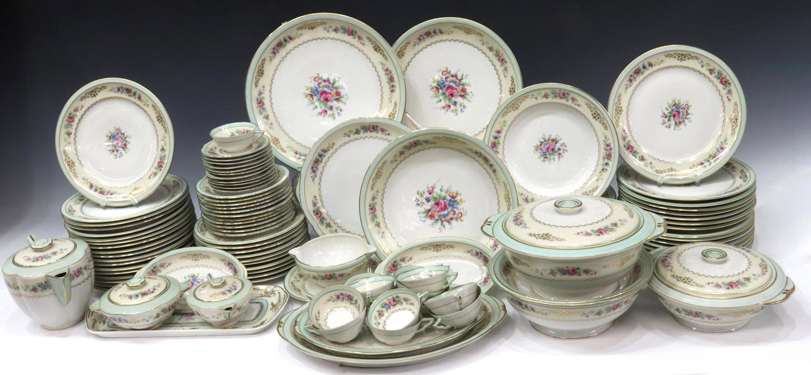 (102) CHARLES AHRENFELDT LIMOGES DINNER SERVICE: (lot of 102) French Charles Ahrenfeldt Limoges porcelain dinner service, having mint trim, parcel gilt foliate wreaths, polychrome floral motifs, comprising: (34) dinner plates, (one) with minute chip