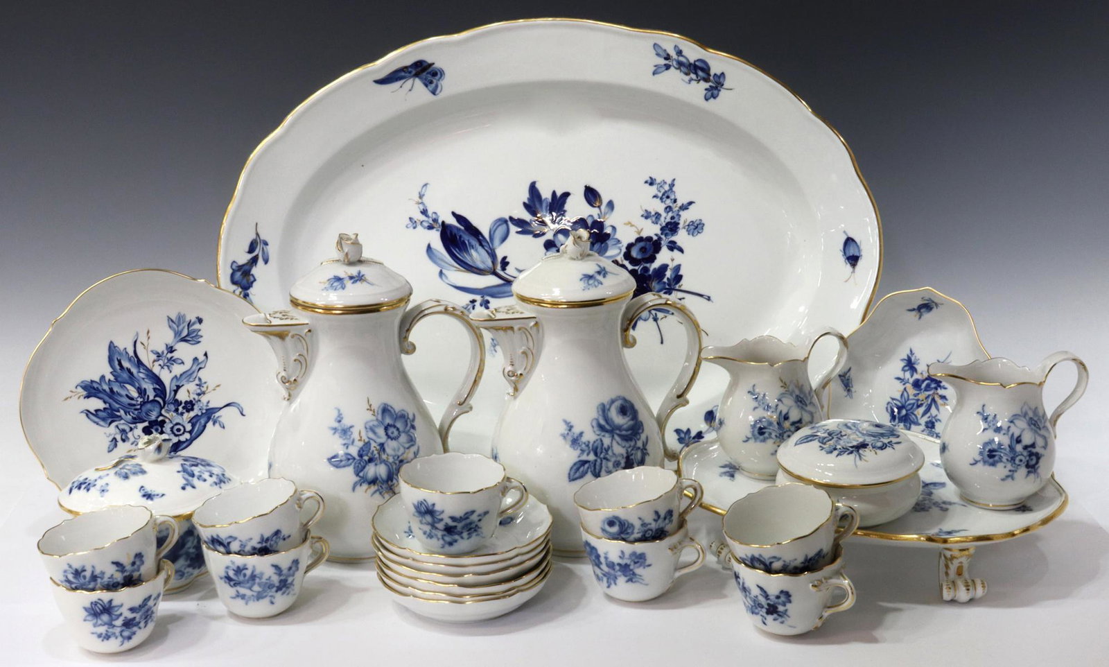 (25) MEISSEN GILT BLUE FLOWER COFFEE SERVICE: (lot of 25) Meissen porcelain coffee service, having gilt trim, depicting flowers and insects in blue glaze, including: (9) demitasse cups with (6) demitasse saucers, approx 4.25"diam, (2) coffee pots