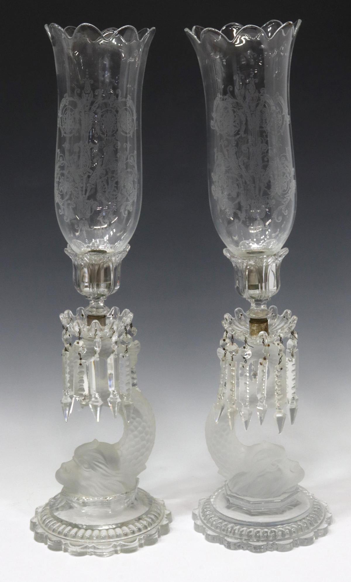 (2) BACCARAT CRYSTAL DOLPHIN HURRICANE LAMPS: (pair) French Baccarat crystal hurricane candle lamps, shade with scalloped rim, etched foliate motifs, silver-tone metal fitter ring, hanging crystal prisms, over frosted stylized dolphin standard, o
