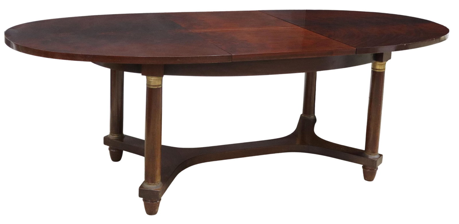 EMPIRE STYLE MAHOGANY TABLE W/ SELF-STORING LEAF: French Empire style mahogany extension table, early 20th c., oval table top, one self-storing 23.5" leaf, rising on columnar legs with gilt metal caps, joined by cross stretcher, on cup feet, accompan