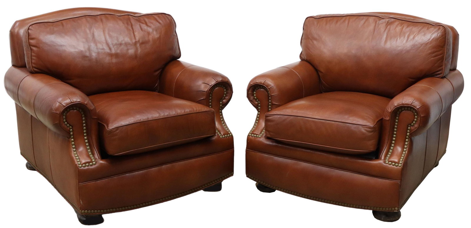 (2) HANCOCK & MOORE LEATHER UPHOLSTERED ARMCHAIRS: (pair) Contemporary leather armchairs, Hancock and Moore, late 20th c., in cognac brown leather upholstery, loose back and seat cushions, rolled arms with brass tack trim, rising on bun feet, some woo