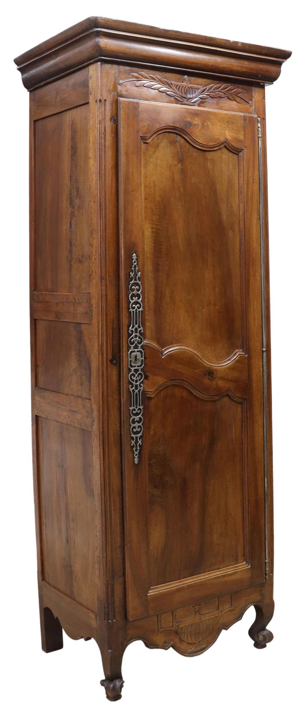 FRENCH LOUIS XV STYLE WALNUT BONNETIERE, 19TH C.: French Provincial Louis XV style walnut bonnetiere, 19th c., case carved with foliate urn motif at crest and apron, having molded cornice, over single paneled cabinet door, with large pierced escutche