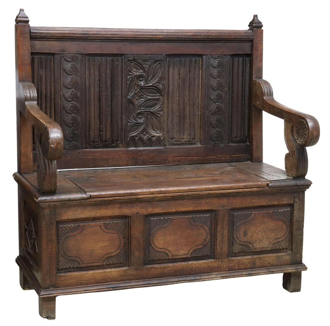 FRENCH CARVED OAK HALL BENCH, 19TH C.: French carved oak hall bench, 19th c., tapered finials, over paneled back with linenfold carving, stylized foliate motifs, curved arms with floral medallions, seat with lift top, revealing open interi