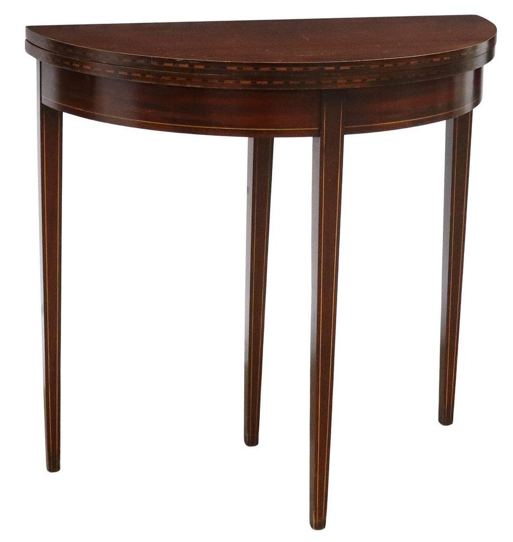 HEPPLEWHITE STYLE MAHOGANY DEMILUNE FLIP-TOP TABLE: Hepplewhite style mahogany table, Brandt Cabinet Works, 20th c., demilune form, accented with string inlay, the hinged top opening to circular form, rising on tapered squared legs, the underside retai