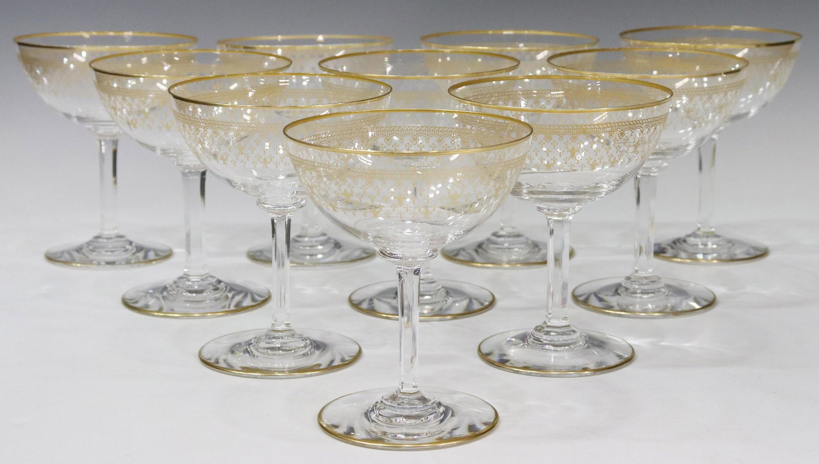 (10) FRENCH BACCARAT GILT FLEUR-DE-LYS CHAMPAGNES: (lot of 10) French Baccarat crystal champagne coupes/ tall sherbets, colorless bowl with gilt rim and fleur-de-lys pattern, over faceted stem, circular foot, acid-etched mark underfoot, approx 4 7/8"h