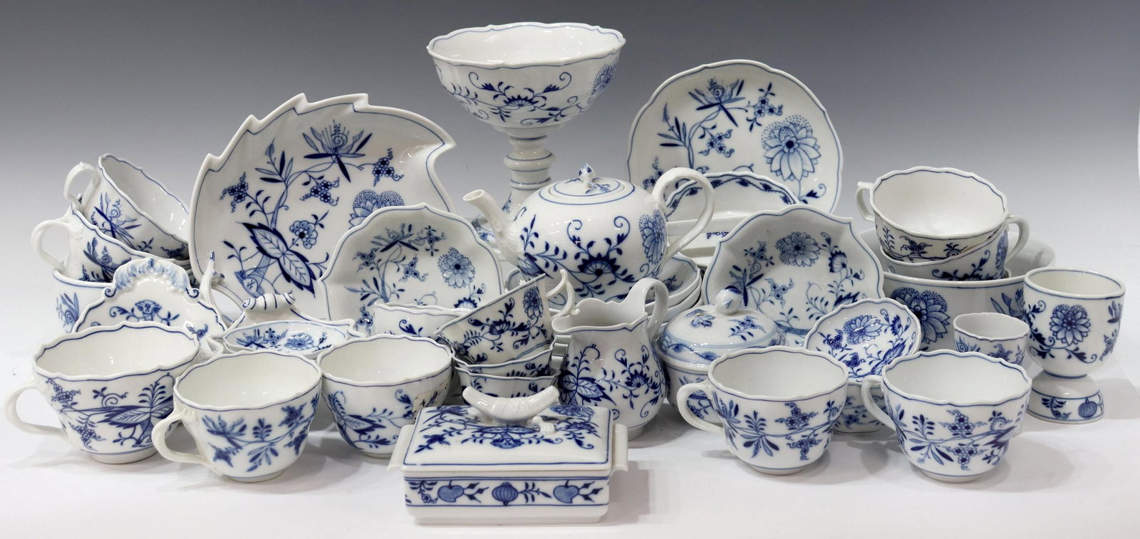 (43) MEISSEN 'BLUE ONION' PORCELAIN TABLEWARE: (lot of 43) Meissen porcelain tableware collection, in the "Blue Onion" pattern, comprising: (1) footed compote, approx 6 1/8"h, 5.75"diam; (1) leaf-shaped dish, approx 8 5/8"l, 7.5"w; (1) footed clam