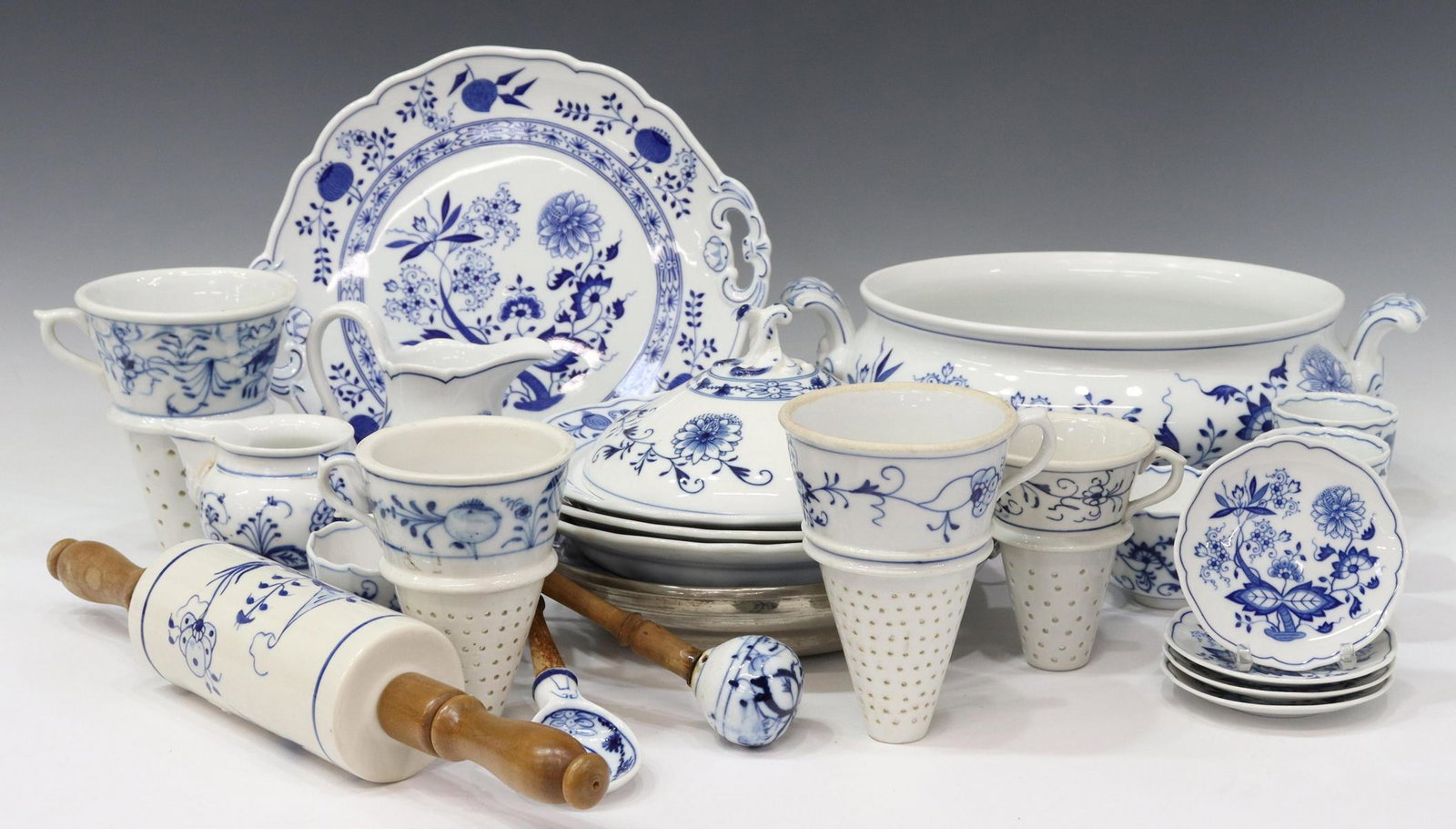 23) BLUE ONION STYLE PORCELAIN SERVICE & TABLEWARE: (lot of 23) "Blue Onion" style porcelain tableware, various makers including Hutschenreuther, Blue Danube Japan, Crown over E, Crown over F, and arrow, comprising: (1) handled cake plate, 11 5/8"l, 10