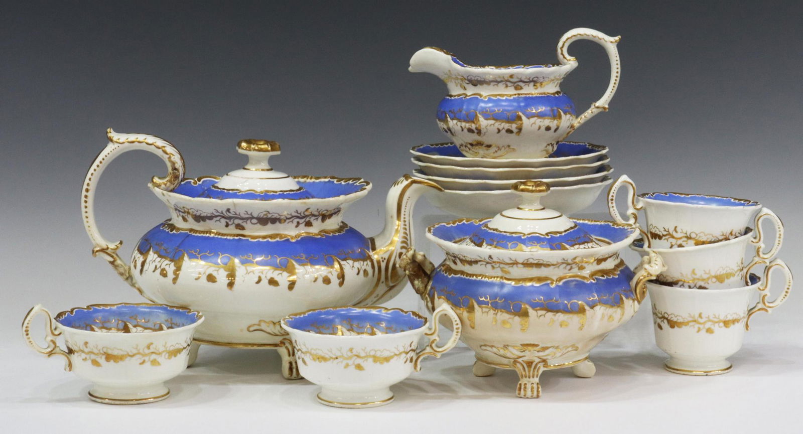 (12) OLD PARIS PORCELAIN PARCEL GILT TEA SERVICE: (lot of 12) Old Paris porcelain tea service, 19th c., blue and gilt decoration on white ground, with vining foliate accents, including: (3) tall handled cups, 3"h, (2) low handled cups, 2.5"h, (4) sau