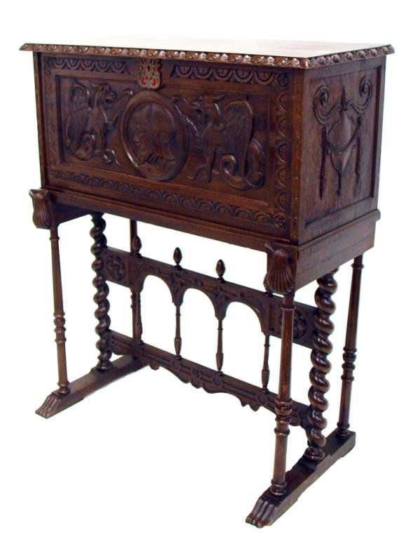 ANTIQUE SPANISH RENAISSANCE STYLE CABINET ON STAND: Spanish Renaissance style walnut vargueno on stand, 19th c., the rectangular case trimmed with ornamental carving, the fall front centering a portrait medallion flanked by a pair of winged griffins, o