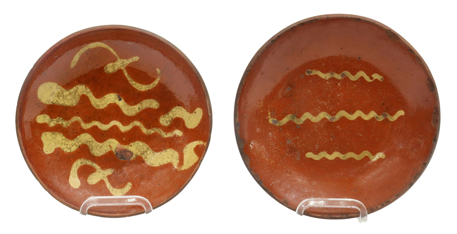 (2) AMERICAN SLIP-DECORATED REDWARE POTTERY PLATES: (lot of 2) American slip-decorated redware pottery plates, Pennsylvania, 19th c., having a coggled rim, encircling linear yellow slip cup designs, unglazed bottom, expected rim and glaze chips, crazin