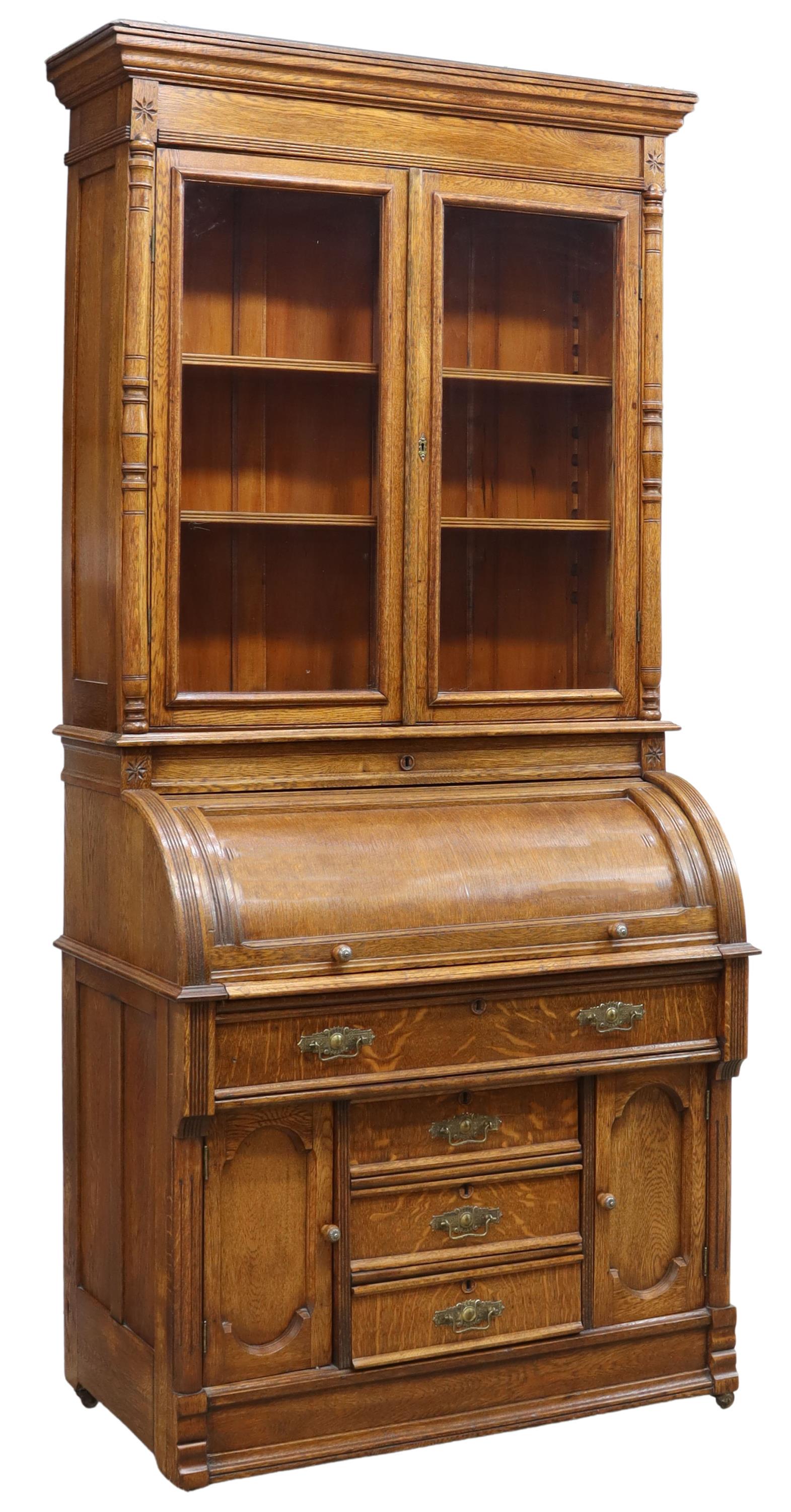 AMERICAN OAK CYLINDER ROLL SECRETARY BOOKCASE: American oak roll-top secretary bookcase, early 20th c., molded cornice over glazed double doors, roll-top cylinder desk opening to pull-out writing surface inset with green felt, interior gallery wit