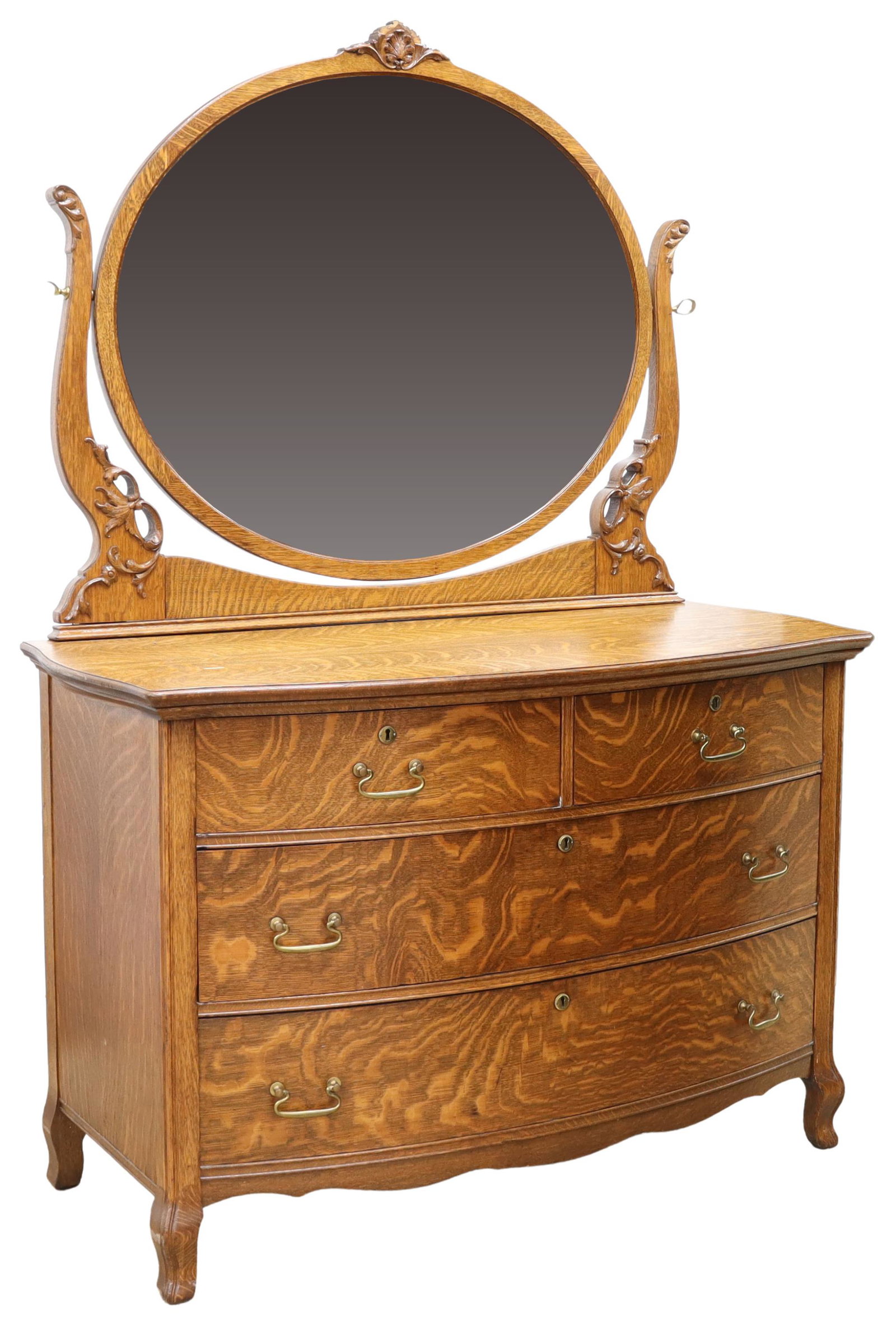 AMERICAN QUARTER SAWN OAK MIRRORED DRESSER: American quarter sawn oak mirrored dresser, c.1900, a central beveled mirror plate tilting on supports with applied foliate motifs, over shaped top, bowfront case fitted with four drawers, rising on s