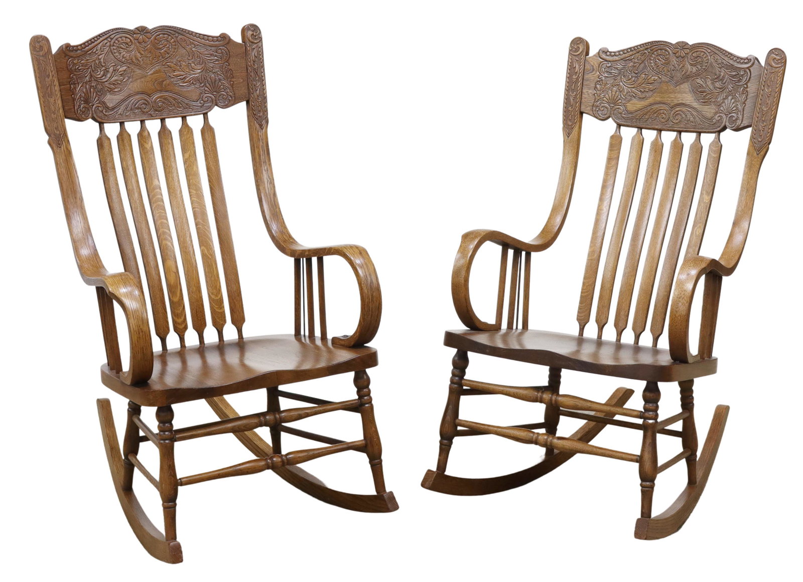 (2) AMERICAN OAK PRESSBACK ROCKING CHAIRS: (pair) American oak pressback rocking chairs, c.1900, shaped crest with heart and foliate scroll motif, over slat back, bentwood arms, rising on stretcher-joined turned legs, on rocker rails, approx 4