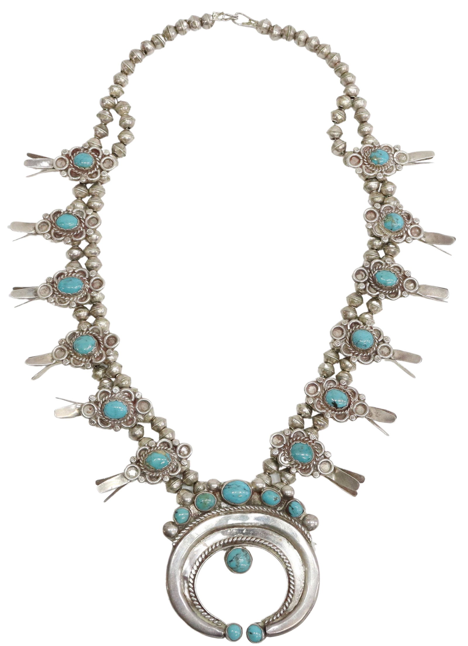 NATIVE AMERICAN TURQUOISE SQUASH BLOSSOM NECKLACE: Native American silver (content unknown) and turquoise squash blossom necklace, featuring twelve turquoise-set blossoms, central naja with three stones, beneath a row of five stones, framed by twisted