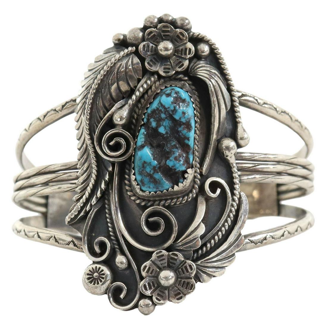 NATIVE AMERICAN SILVER & TURQUOISE CUFF BRACELET: Native American silver (content unknown) cuff bracelet, signed with conjoined ?JY?, central bezel-set turquoise in silver surround of feathers, flowers, and scrolls, beaded accents, twisted wirework, 