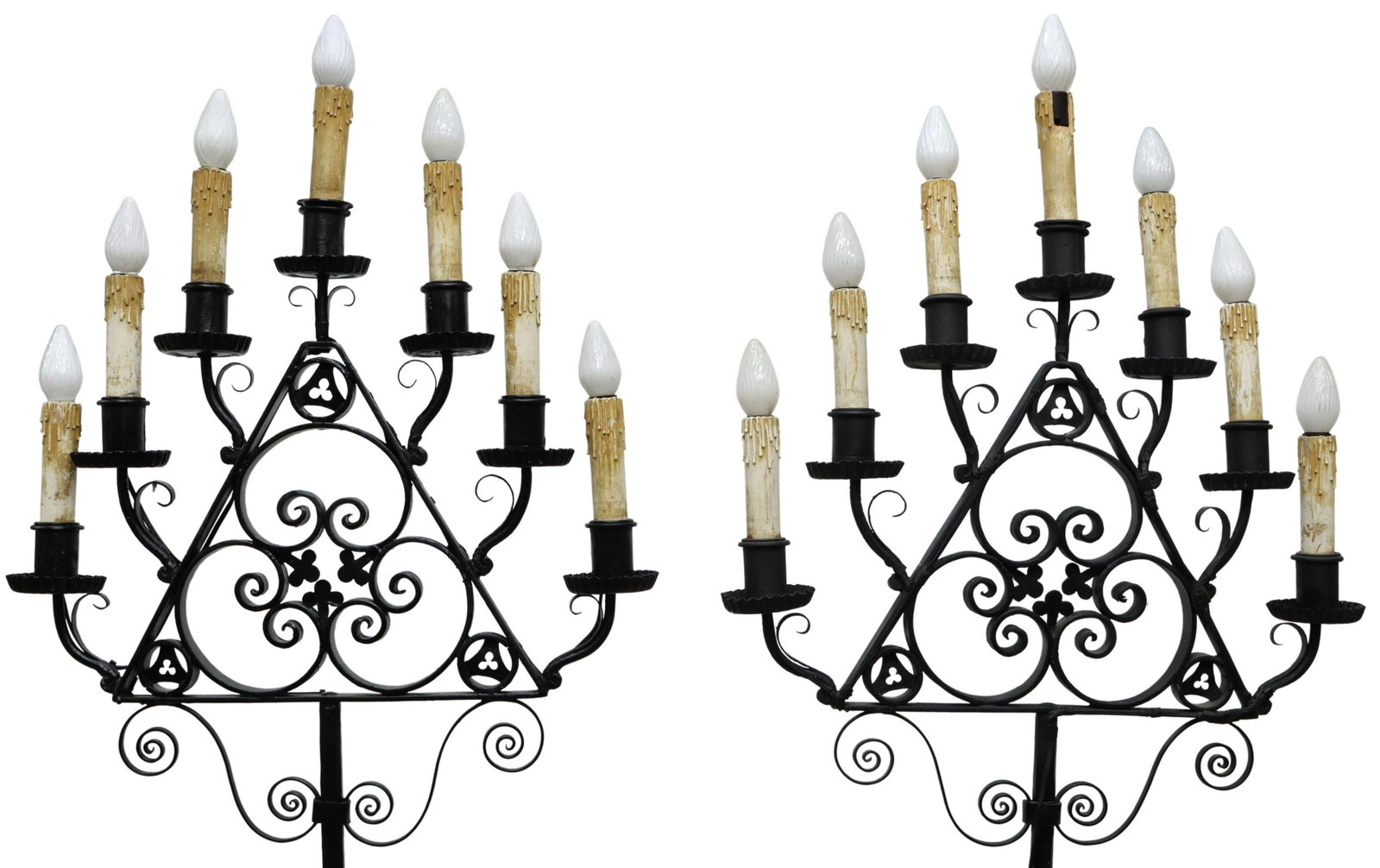 (2) WROUGHT IRON SEVEN-LIGHT FLOOR CANDELABRA: (pair) Large Gothic Revival wrought iron floor candelabra, now electrified, having scrolled triangular capitals supporting seven faux candles, rising on a twisted floral standard, ending in volute tri