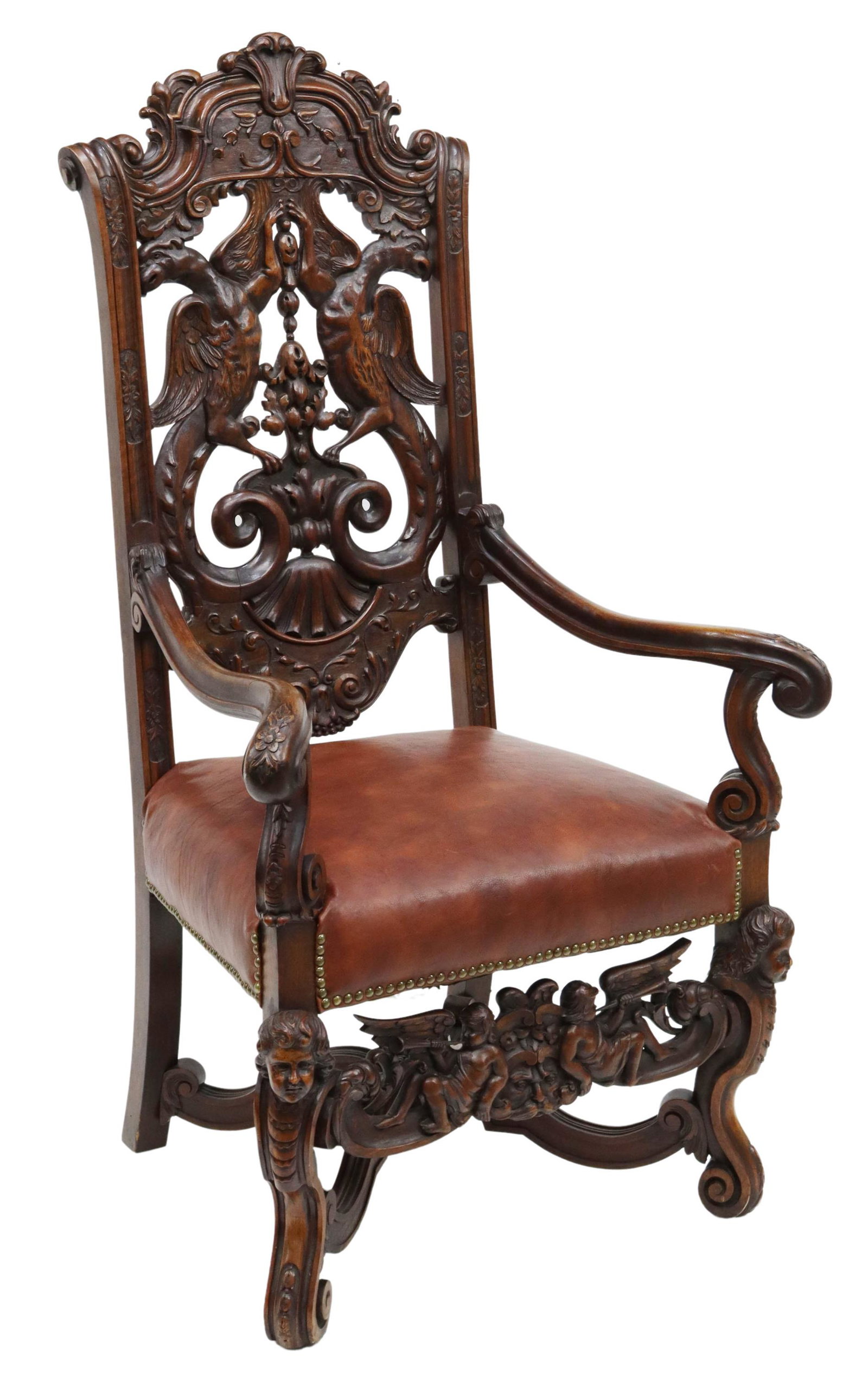 HEAVILY CARVED RENAISSANCE REVIVAL WALNUT ARMCHAIR: Renaissance Revival walnut armchair, heavily carved with beast and trumpeting cherub motifs, having pierced back splat, scrolled handholds, over leather upholstered seat, fixed with nail head trim, fo