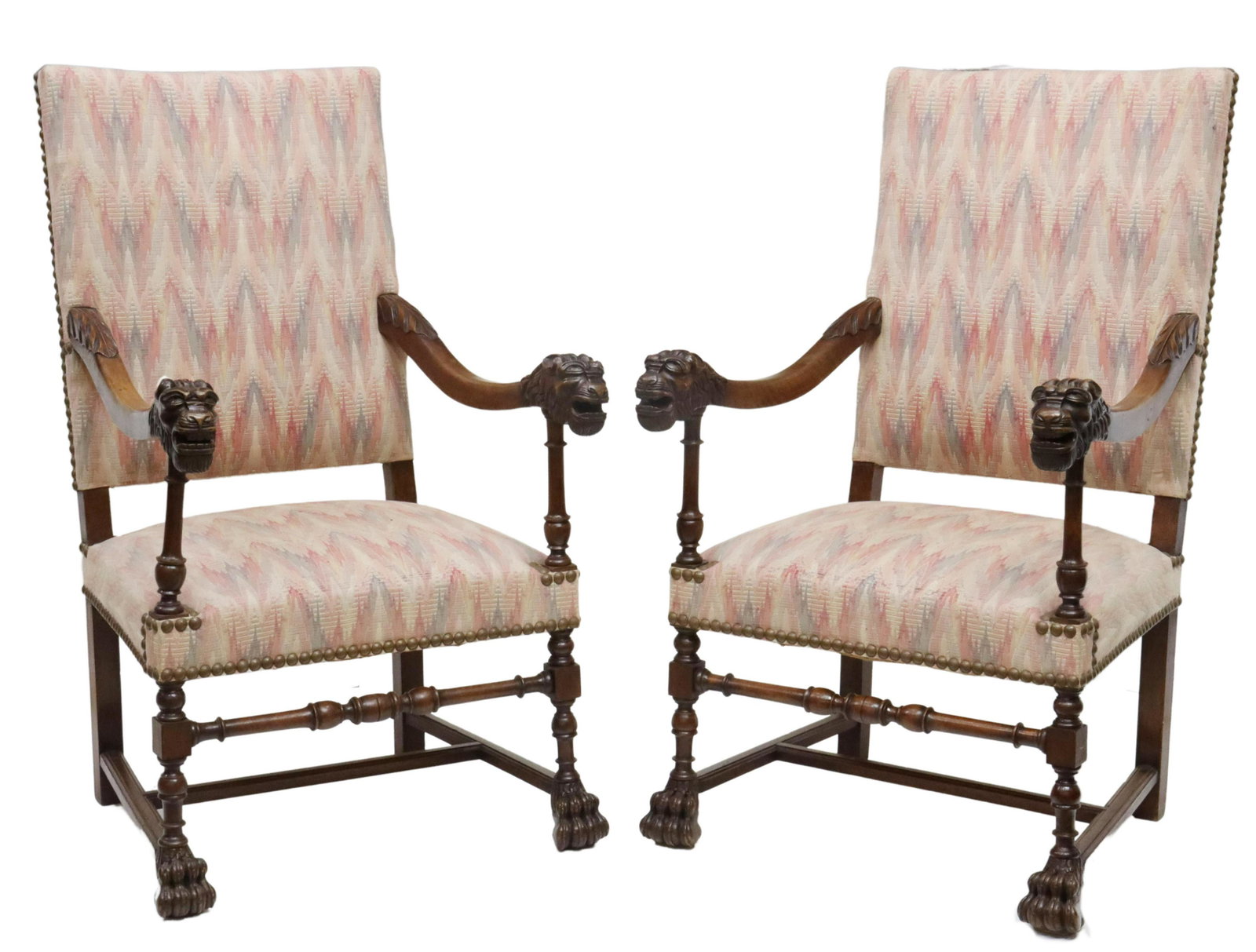 (2) FRENCH LOUIS XIII STYLE LION HEADS FAUTEUILS: French Louis XIII style walnut armchairs, late 19th c., having later nailhead accented upholstery, curving arms terminating in carved lion heads, stretcher-joined turned supports with paw feet, approx