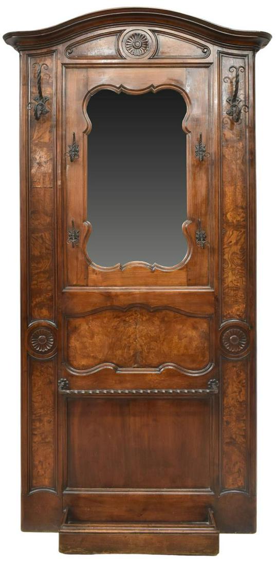 FRENCH BRESSANE BURLWOOD HALL TREE: French Provincial walnut hall tree, Bresse, late 19th c., arched molded cornice, carved floral roundel, backboard accented with burlwood panels, shaped mirror plate, wrought iron hooks, umbrella/ cane