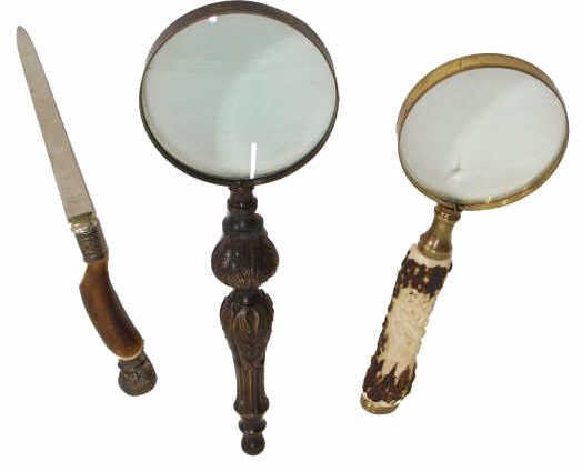 CARVED STAG HANDLE MAGNIFYING GLASS, LETTER OPENER: (lot of 3) Decorative desk accessories comprising: (2) large magnifying glasses, one with a foliated metal handle, 12"l, 4"d, and the other with a handle stag handle carved with two running deer in re