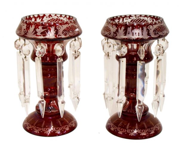 ANTIQUE BOHEMIAN RUBY TO CLEAR PRISM TABLE LUSTRES: (pair) Bohemian glass lusters, early 20th c., ruby etched to clear glass, figures of stags, birds, castles at top, domed etched base, hung with large faceted prisms, all intact with some loss to tips,