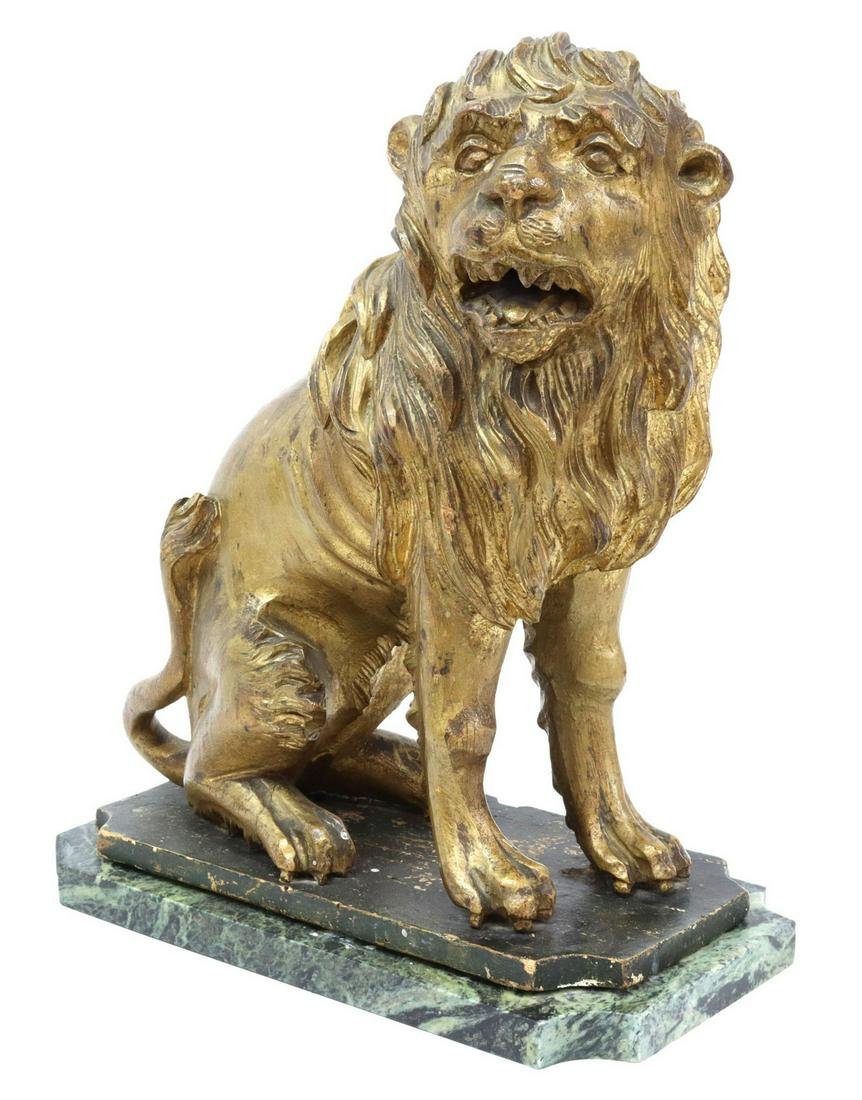 ANTIQUE CARVED GILTWOOD LION SEJANT MARBLE BASE: Antique carved giltwood lion sejant, juvenile lion with open mouth, attenuated body with delineate ribs, seated on an ebonized wood base, further raised on a green marble plinth, approx 14.5"h, 11.75"
