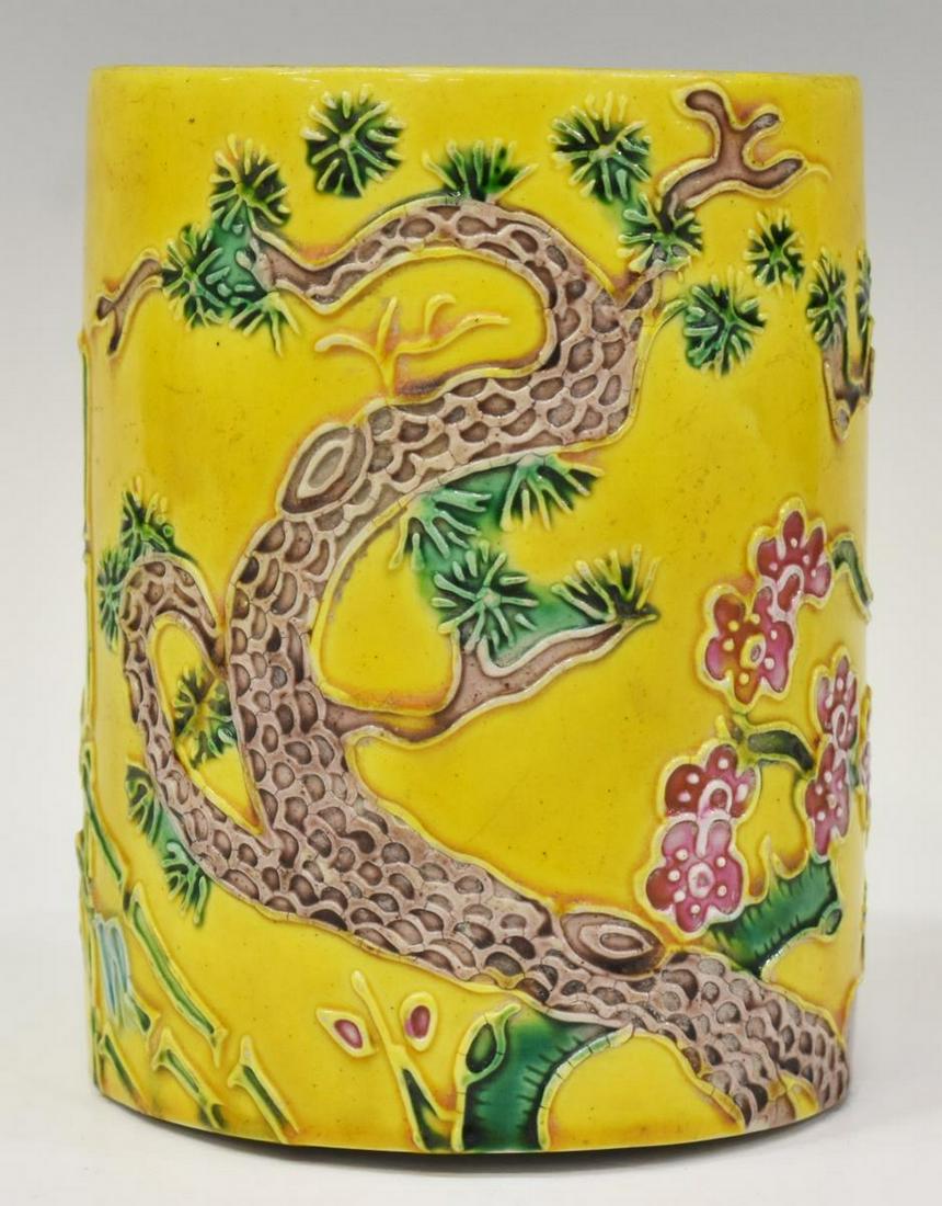 CHINESE FAMILLE JAUNE PORCELAIN BITONG BRUSH POT: Chinese yellow porcelain bitong / brush pot, 20th c., of cylindrical form, having floral and foliate relief decoration, honorific Kangxi style six-character mark underfoot, approx 5"h, 3.75"diam, 1lbs
