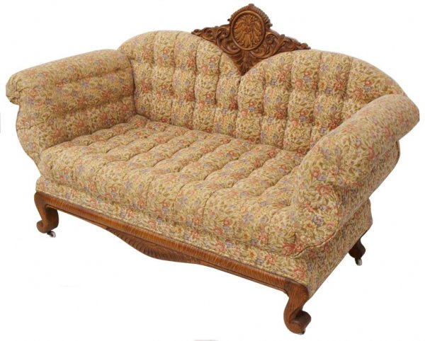 UNUSUAL AMERICAN ANTIQUE TIGER OAK ADJUSTABLE SOFA: American tiger oak upholstered sofa, c. 1880, the tufted back centering an elaborately carved crest featuring Borius the North Wind, adjustable out-scrolled arm rests open (5 positions) to form a dayb