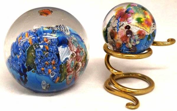 JOSH SIMPSON ART GLASS 'PLANET' GROUP: (lot of 2) Josh Simpson art glass orbs comprising: (1) 'planet' paperweight, signed and serial number underfoot, 3.25"h; (1) 'mini planet' on a spiral gilt metal stand, signed Josh 06, 1.75"h; 2lbs