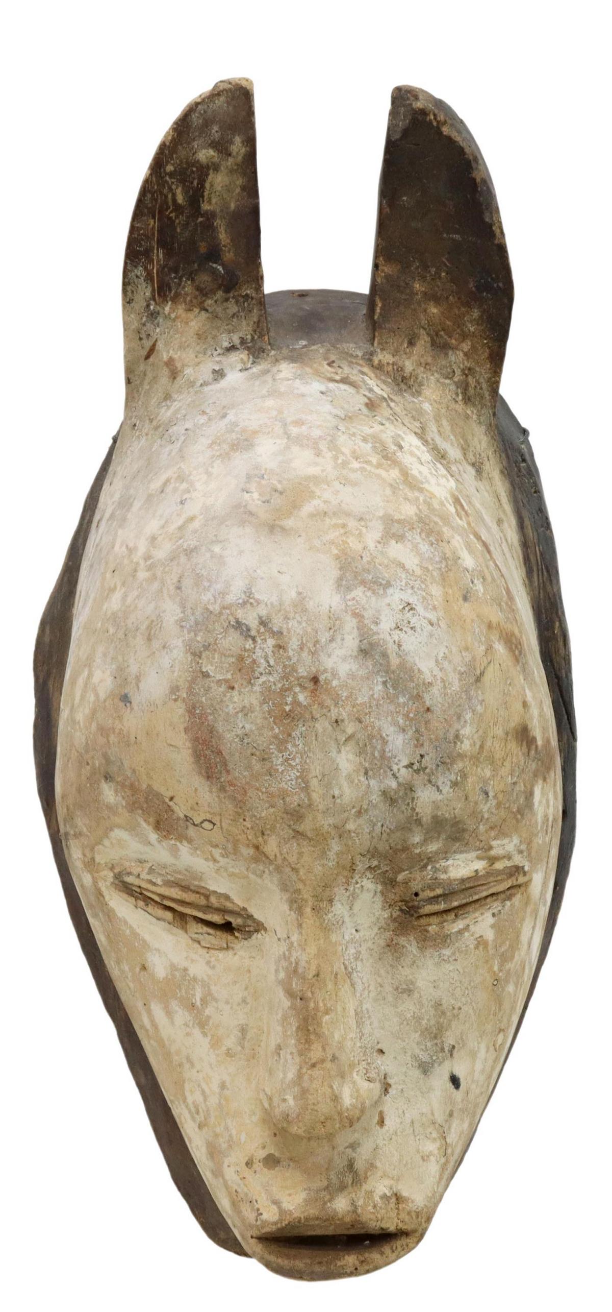 AFRICAN PIGMENTED & CARVED WOOD GHOST MASK: African figural ghost mask, possibly Fang peoples, Gabon, carved wood visage having two ears or horns over large domed forehead, pierced slit eyes, triangular nose and low pursed mouth, decorated in w