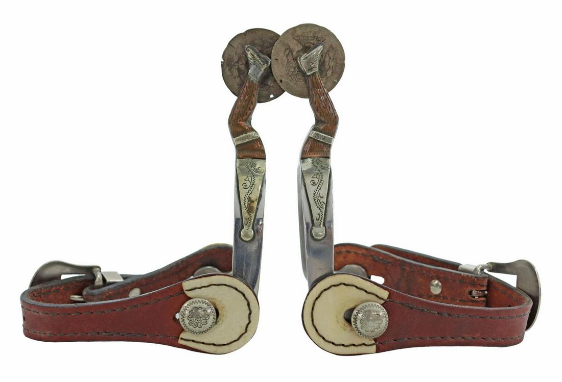 (PAIR) J. HOLDER CUSTOM GAL LEG COWBOY SPURS: (pair) Gal leg spurs, both marked J. Holder, (one) etched on the interior heelband "Custom by J. Holder," each with silvered arrow heads, 1.5" rowels made from U.S. Morgan silver dollars, belt buckle
