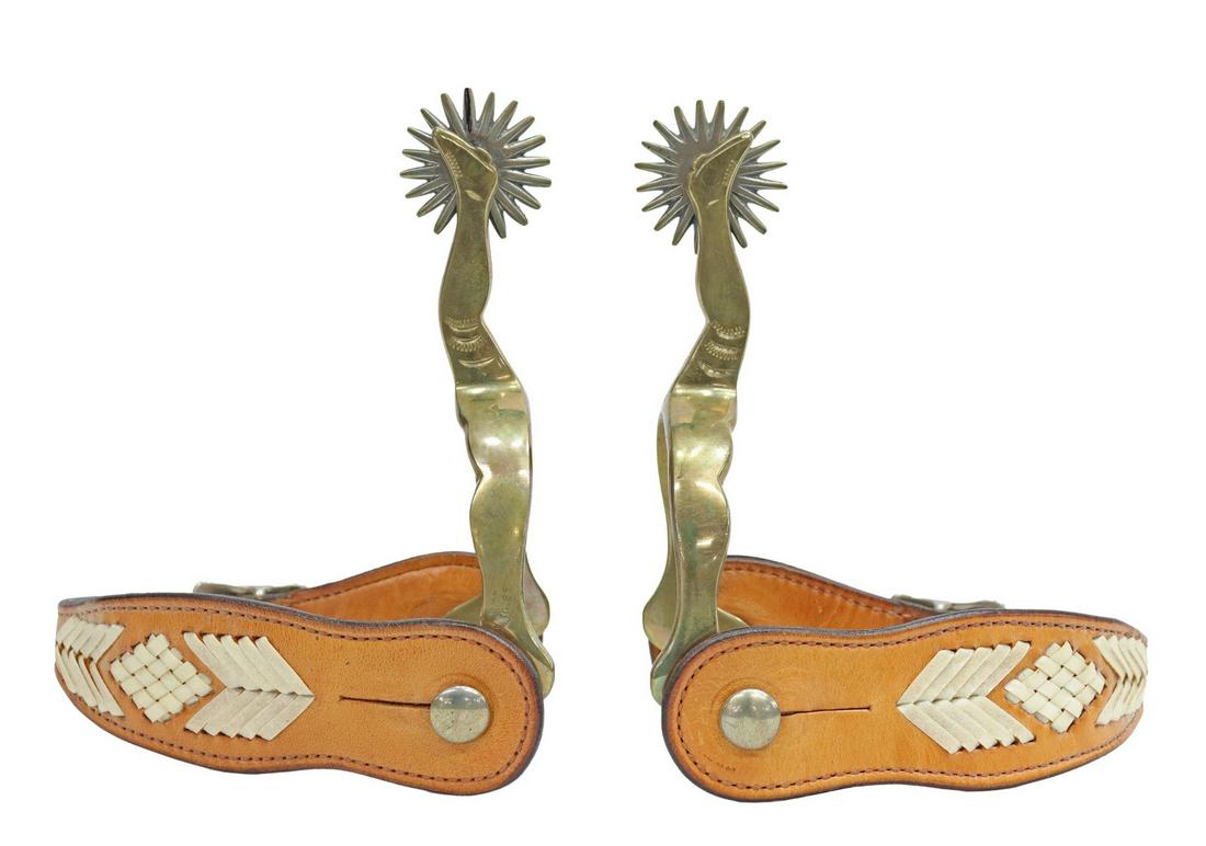 (PAIR) WILD TIMES BRASS GAL LEG COWBOY SPURS: (pair) Brass Gal Leg spurs, (one) marked "Wild Times" within an oval, 1.5" rowels with 20 points, leathers, yoke: approx 2 5/8"w, 2.5"d Start Price: $60.00
