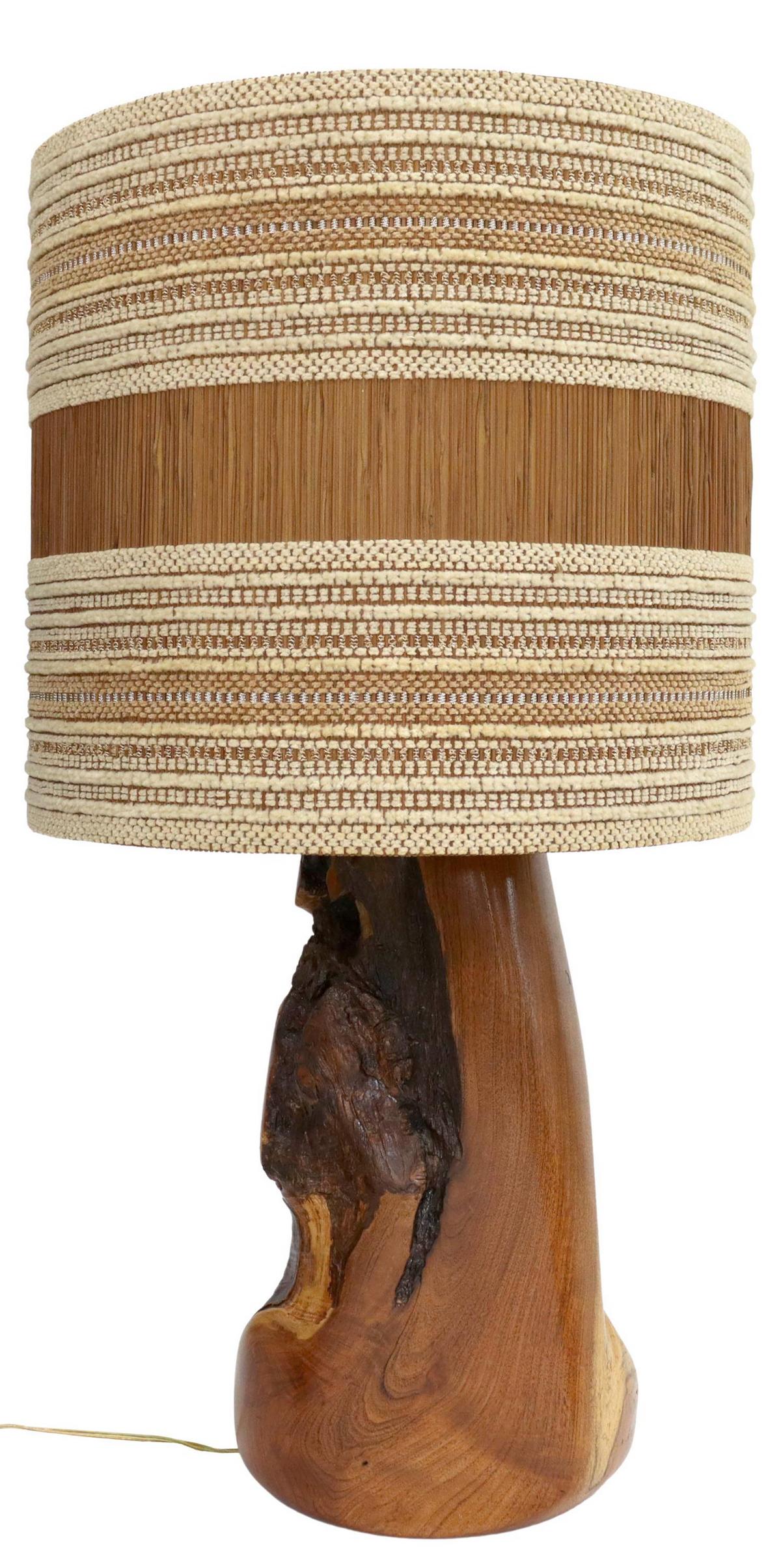 LARGE LIVE EDGE SCULPTURAL TABLE LAMP & SHADE: Live edge wood sculpture, now fashioned as a table lamp, with woven fabric and slatted wood shade, small loss to shade trim at top, base to socket: approx 25"h, 10"w, 8.5"d, shade: approx 17.5"h, 18.5