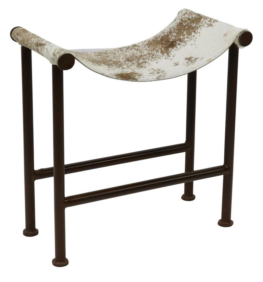 JAN BARBOGLIO 'SADDLE BENCH' IRON & COWHIDE STOOL: Western iron and cowhide 'Saddle Bench' stool, designed by Jan Barboglio (Mexico, 20th c.), having brindle sling seat, over iron frame, rising on stretcher-joined tube legs, ending in disc feet, beari