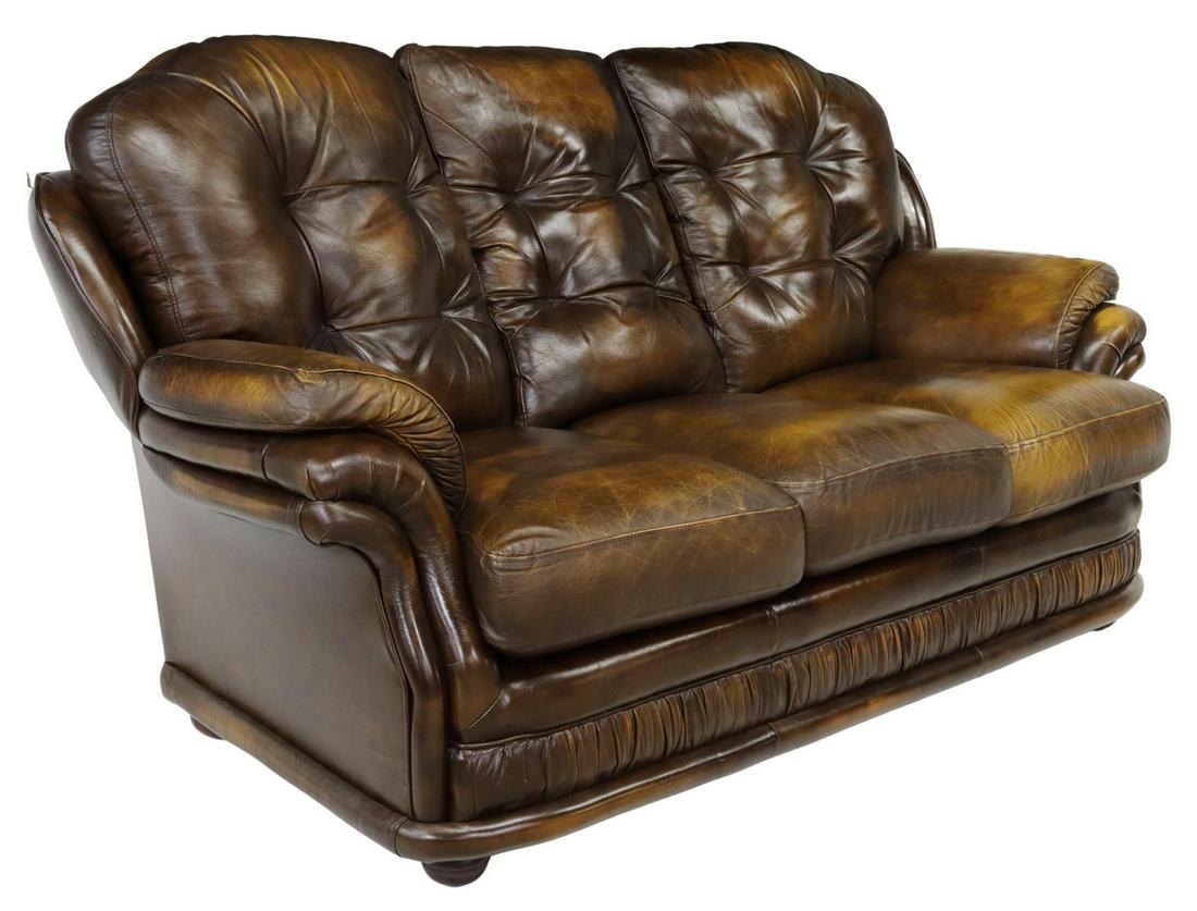 ENGLISH TUFTED BROWN LEATHER THREE-SEAT SOFA: English three-seat sofa, Thomas Lloyd, late 20th c., in brown leather upholstery, with tufted back cushions, padded arms, ruched apron, nail head trim, three loose seat cushions, rising on bun feet, r