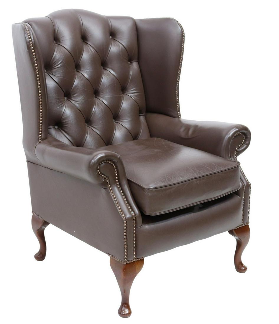 QUEEN ANNE STYLE LEATHER WINGBACK ARMCHAIR: English Queen Anne style wingback armchair, late 20th c., in brown leather upholstery, with button-tufted back, rolled arms with nailhead accents, loose seat cushion, rising on cabriole legs, ending i