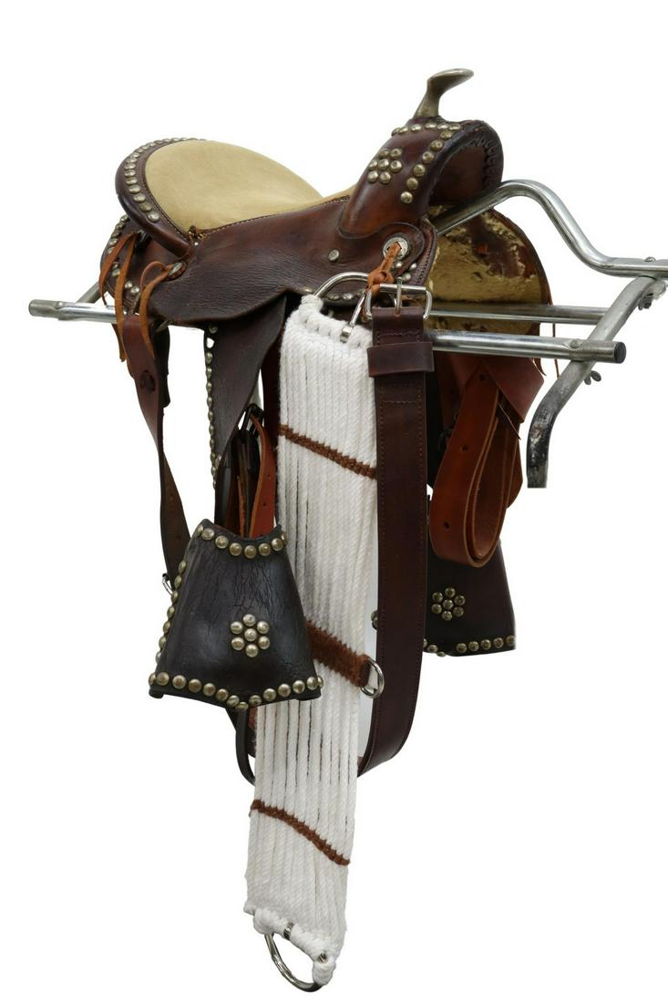 WESTERN YOUTH SADDLE: Western youth saddle, having suede seat, exposed metal horn, accented with conchos and nail head trim, accompanied by 30" rope girth, seat: 12"w, 16.25"l; wood stirrups: 5"w; overall: 18"l, 14"w; 16lb