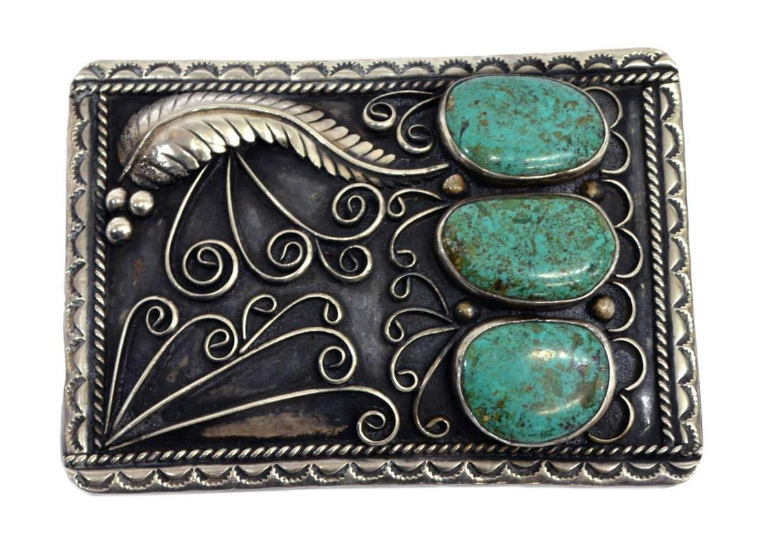 NATIVE AMERICAN SILVER & TURQUOISE BELT BUCKLE: Native American silver (content unknown) belt buckle, signed W or M to the back, stamp work border, enclosing three bezel set turquoise stones, feather and scroll motif, approx 2.5"h, 3.5"l, rear buck