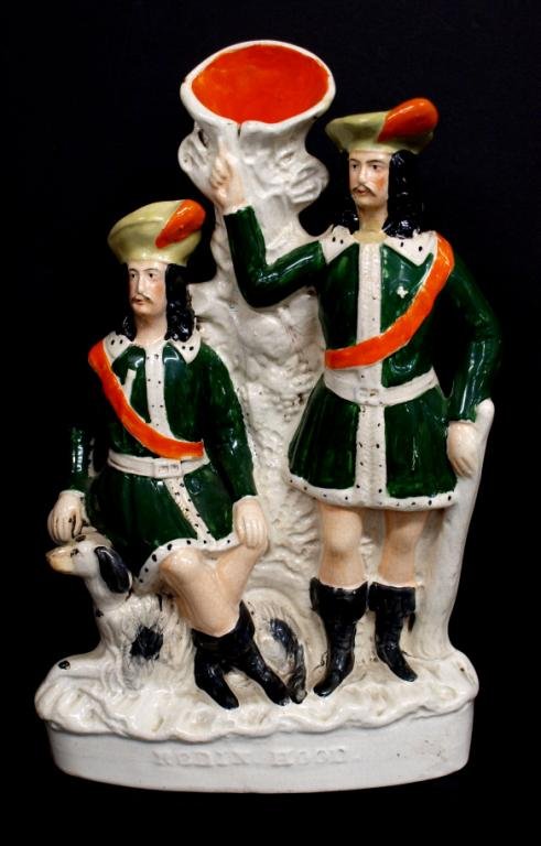 LARGE ANTIQUE STAFFORDSHIRE "ROBIN HOOD" VASE: English porcelain Staffordshire figural spill vase, mid 19th c., modeled as Robin Hood seated next to a dog and Little John, both in green garments and black boors, the title "Robin Hood" in relief at