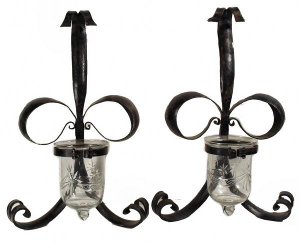 BOW FORM IRON & CUT GLASS WALL CANDLE SCONCES: (pair) Bow form scrolled iron wall sconces, each set with a colorless cut glass candle holder, 15"l, 8.25"w; 7lbs total