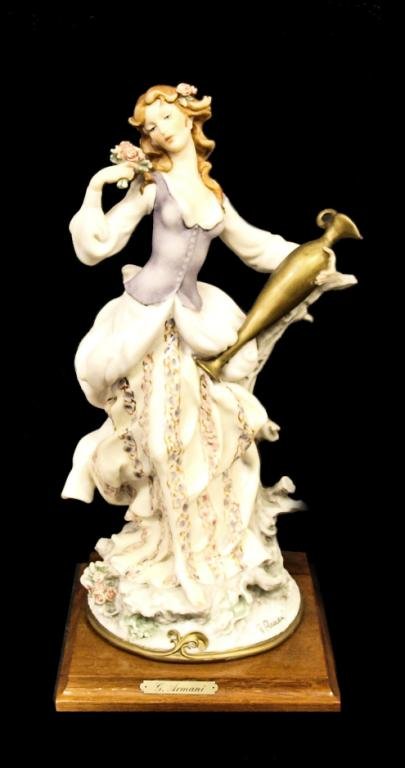 ITALIAN GIUSEPPE ARMANI WOMAN WITH FLOWERS FIGURE: Giuseppe Armani figure modeled as a young woman holding roses and a gilt urn, Armani signature and blue N under crown mark at base, 14.5h, 7.75"w, 7.75"d, 6.5lbs