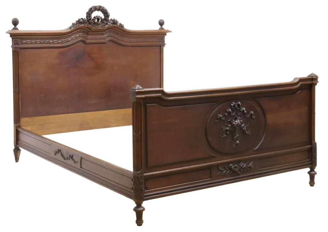 FRENCH LOUIS XVI STYLE CARVED MAHOGANY BED: French Louis XVI style mahogany bed, late 19th c., headboard with floral wreath crest, pomegranate finials, laurel leaf molding, fluted corner posts, footboard with carved basket of flowers over cross