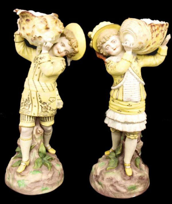 LARGE CONTINENTAL PORCELAIN FIGURES HOLDING SHELLS: (lot of 2) Large Continental porcelain figures modeled as a boy and girl in matching yellow and parcel gilt costumes holding large sea shells, each impressed underfoot 'No. 726 7', hand numbered 18, r