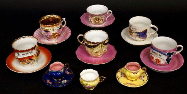19TH C. GERMAN PARCEL GILT LUSTER PORCELAIN CUPS: (9) German gilded luster porcelain cups, 19th c., all but one with matching or associated saucers, all having applied flowers and gilt details, one with gilded bowl, examination under blacklight showi