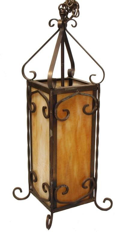 SLAG GLASS & SCROLLED IRON HANGING LIGHT FIXTURE: Large iron and slag glass hanging light fixture, the panes of glass framed by iron scrolls, electrified, 26"l, 10"w, 13lbs