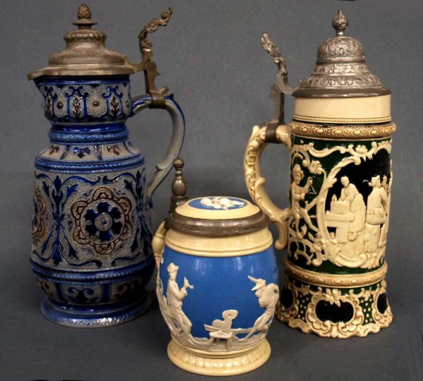 ANTIQUE STEINS, METTLACH #2211, SALT GLAZE: (lot of 3) Stein grouping, comprising: (1) Villeroy & Boch Mettlach stein, #2211, figural relief scene on a blue ground, 5"h; (1) large antique blue salt glaze stein, impressed 566 underfoot, intact w