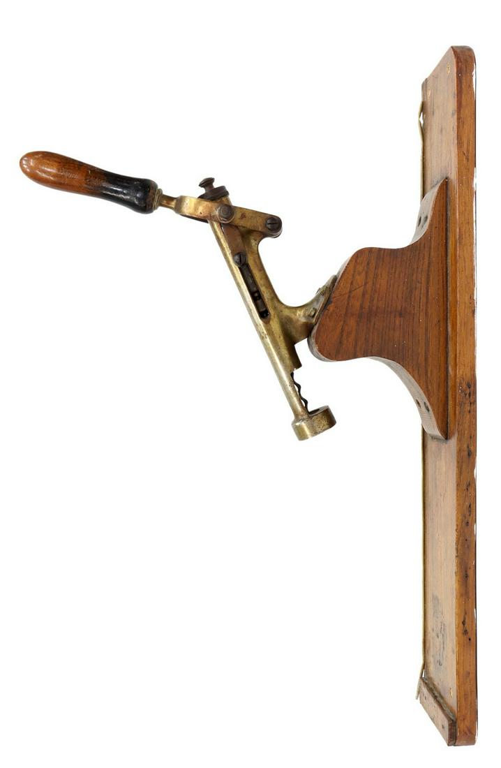 FRENCH OAK-BACKED WALL MOUNTED CORKSCREW: French wall mounted wine bottle opener, brass and iron corkscrew, lever handle, oak backboard, approx 28"h, 5.5"w, 12.5"d, 8.5lbs Start Price: $200.00