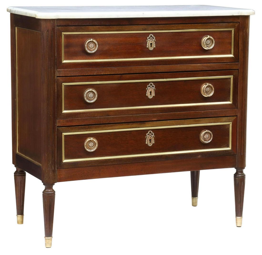 FRENCH LOUIS XVI STYLE MARBLE-TOP MAHOGANY COMMODE: French Louis XVI style marble-top mahogany commode, early 20th c., projecting corner posts, three drawers with brass trim, rising on tapered fluted legs, ending in brass-capped feet, approx 33"h, 33.7